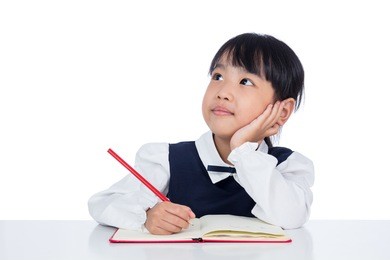 asian little chinese girl writing homework in isolated white background