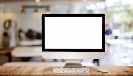 work place concept : mock up blank screen computer desktop with keyboard in cafe or co-working background.