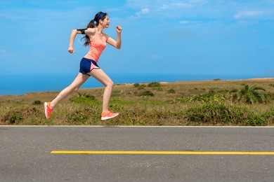 side view photo of professional young female runner player running on road for training personal speed and explosive force at holiday weekend.