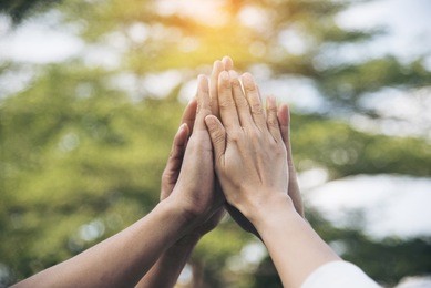 teamwork concept. group of people make a high five in the air to show power of team building. multiethnic working together in group seminar. team collaboration in business situation
