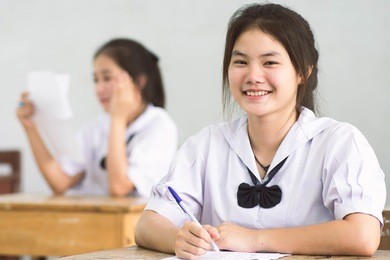 smile young girl student reading and writing exam with not stress.