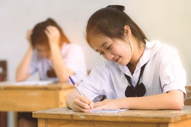 smile young girl student reading and writing exam with not stress.