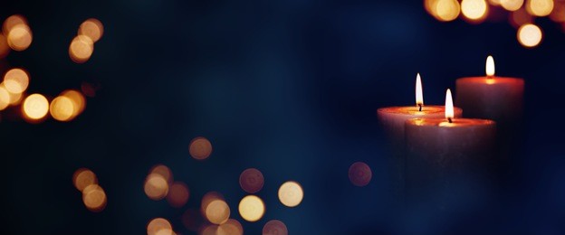 candle lights in blue darkness with golden bokeh for solemn moments