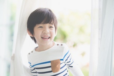 portrait of cute asian child at the open window
