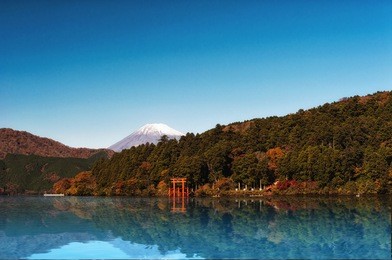 red torii gate on the shore of lake ashi, near mount fuji in hakone, japan.