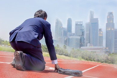 businessman at starting line on tracks focus on the city. business startup concept. 