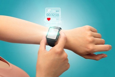 female hand with smartwatch and running concept above.