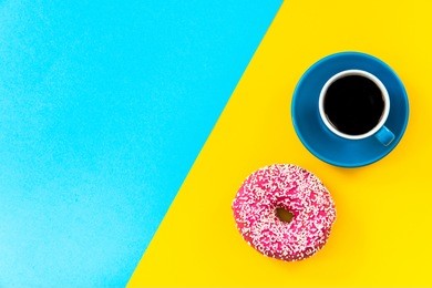 coffee and donut on bright background, top view, flat lay