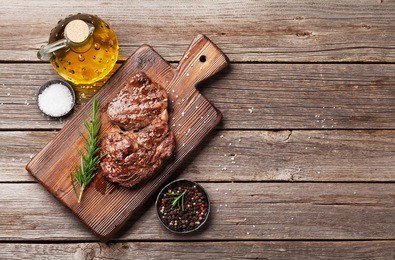 grilled beef steak with spices on cutting board. top view with copy space