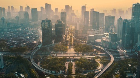 jakarta, indonesia. may 12, 2017: aerial view of circular flyover in modern city at sunset time