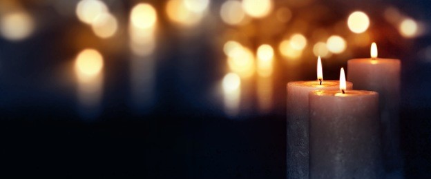 dark blue background with burning candles and golden bokeh for a solemn occasion