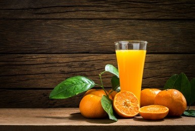 still life glass of fresh orange juice on vintage wood table with copy space background