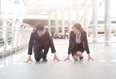 businessman and businesswoman ready for race in business with on city street background.