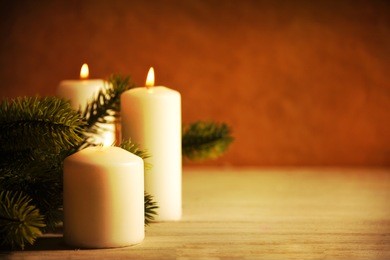 christmas candles and ornaments over dark background with lights