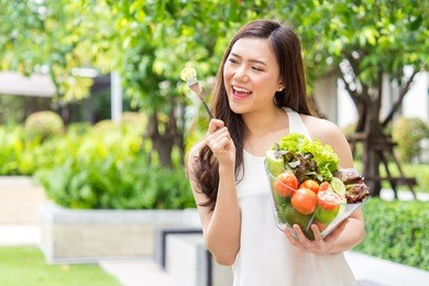 young beautiful asian woman eating fresh clean food with cucumber vegetables and fruits for good healthy over green background, healthy food woman for diet 
