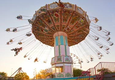 a pink carousel ride spins fast in the air in florida at sunset