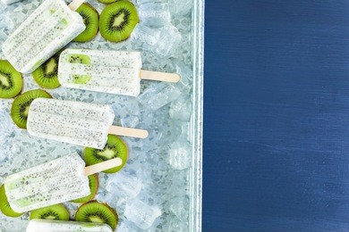 kiwi coconut chia popsicles with fresh kiwi and ice in metal tray.