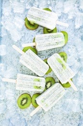 kiwi coconut chia popsicles with fresh kiwi and ice in metal tray.