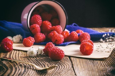 raspberries scattered on a wooden table
