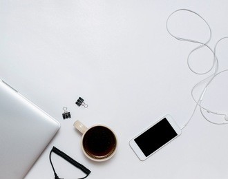 top view of white office desk with laptop, smartphone, cup of coffee, clips and others . top view with copy space. minimal concept.