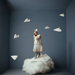 conceptual photo manipulation of walk in the air. girl and paper airplanes