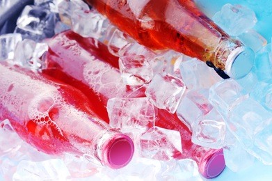 bottles with  tasty drink in ice