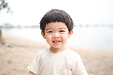 portrait baby cute boy playing in the sandy beach, happy and smiling child.