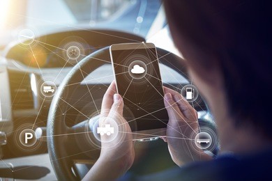 woman driver using smart self-driving car  control system on a hand phone. futuristic driving technology concept .