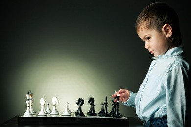 little serious boy plays chess