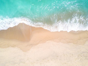 aerial view of sandy beach and ocean with waves