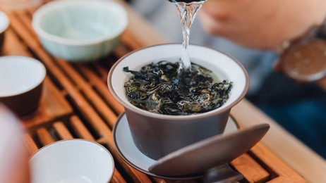 brewing chinese tea in ceramic gaiwan during the tea ceremony close-up. gaiwan and other tea tools for the ceremony