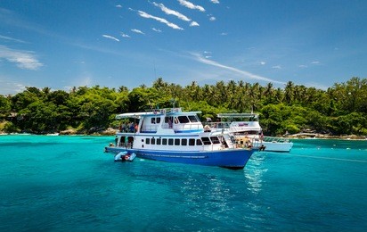 island tour boat at racha yai island off the coast of phuket, thailand