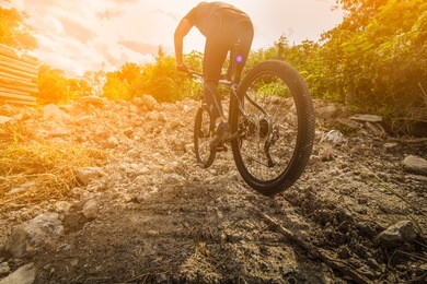 cyclist riding mountain bike on trail at sunrise