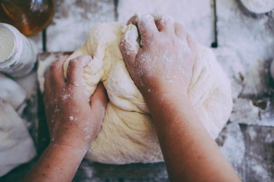 close up view of baker kneading dough. homemade bread. hands preparing bread dough on wooden table. preparing traditional homemade bread. woman hands kneading fresh dough for making bread