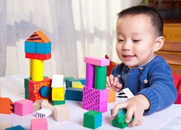 boy playing with wooden blocks