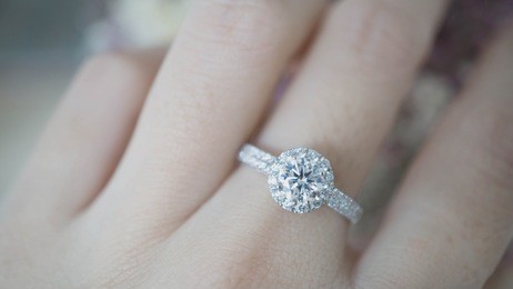 close up of elegant diamond ring on female finger. (soft and selective focus)