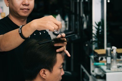 hairdresser cutting hair of male client