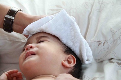 1 year asian baby boy get sick,he has high fever, father making tepid sponge for him.a tepid sponge bath may reduce body temperature .baby is crying.