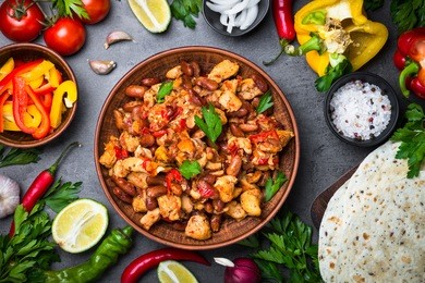 cooking mexican taco with meat beans and vegetables at black slate table. latin american food background. top view.
