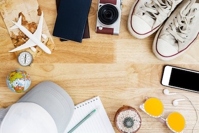 outfit and accessories of traveler on blue background with copy space, travel concept.overhead view of traveler's accessories, essential vacation items, travel concept on wooden background. top view
