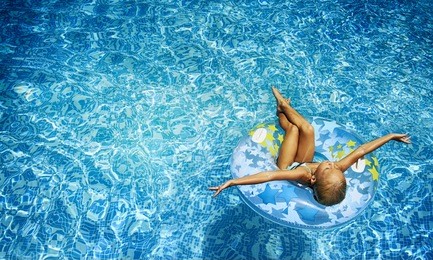 swimming, summer vacation - lovely girl playing in blue water 