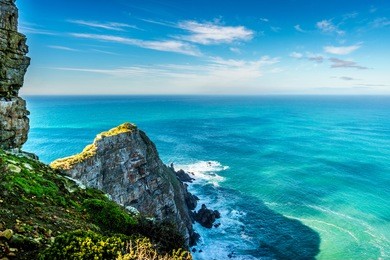 rugged rocks and steep cliffs of cape point in the cape of good hope nature reserve on the southern tip of the cape peninsula in south africa surrounded by the turquoise waters of the atlantic ocean