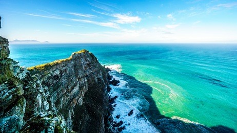 rugged rocks and steep cliffs of cape point in the cape of good hope nature reserve on the southern tip of the cape peninsula in south africa surrounded by the turquoise waters of the atlantic ocean