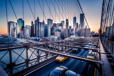 cars speeding at sunset on brooklyn bridge, manhattan. one of the most iconic bridges in the world, a must see attraction when visiting new york.