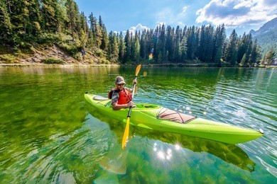 shallow scenic lake kayak tour. caucasian kayaker on the lake misurina in northern italy. italian dolomites.