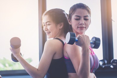 pretty women workout with dumbbell in fitness gym.