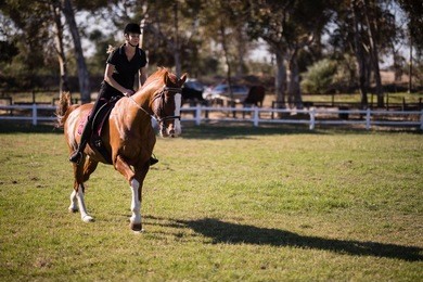 female jockey riding horse at equestrian center