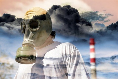 man in a gas mask against a pipe polluting air