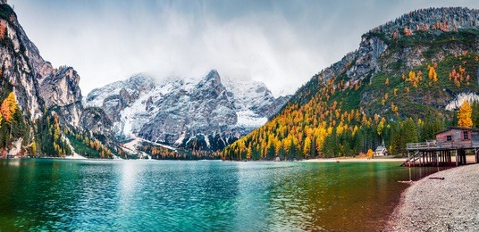 boat hut on braies lake with seekofel mount on background. colorful autumn panorama of italian alps, naturpark fanes-sennes-prags, dolomite, italy, europe. traveling concept background.