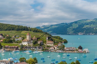 view on beautiful small city, lake thun, marine and many boats. city of spiez, canton bern, switzerland